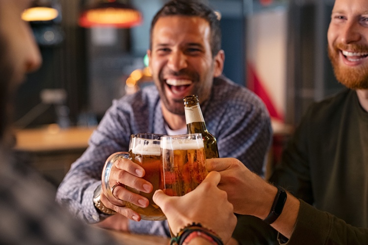 A group of friends clinking beer glasses in a pub.