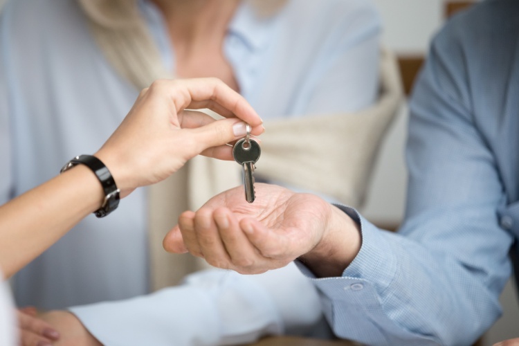 A couple receiving keys from an estate agent.